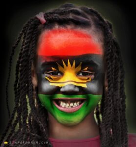 a child with Biafran flag-design painted on her face
